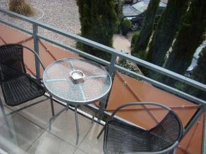 朗根阿根贝拉卡萨酒店的阳台上的玻璃桌和两把椅子