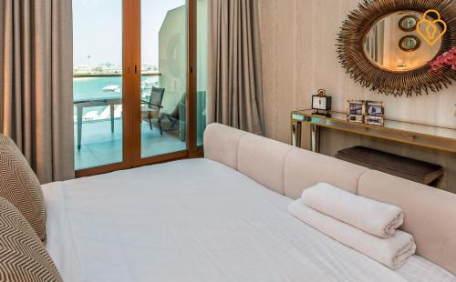 迪拜吉斯普利斯度假屋 - 东棕榈景的卧室配有白色的床和镜子