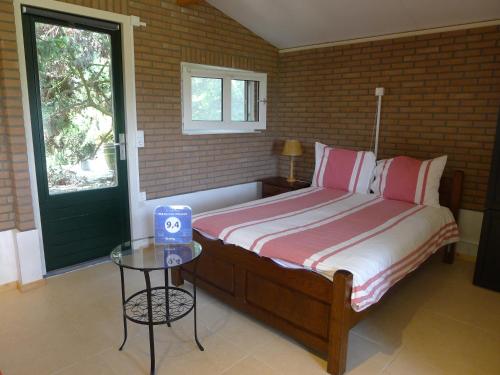 罗赫尔小葡萄园住宿加早餐酒店的一间卧室配有一张带桌子和窗户的床