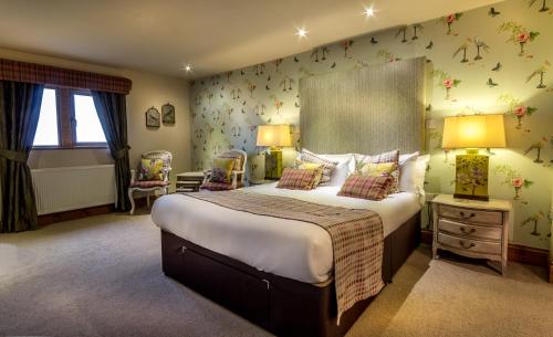 霍姆弗斯The Huntsman Inn的卧室配有一张墙上鲜花的大床