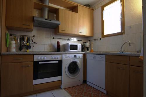 梅斯尼圣佩尔Le Port Mesnil的厨房配有洗衣机和微波炉。