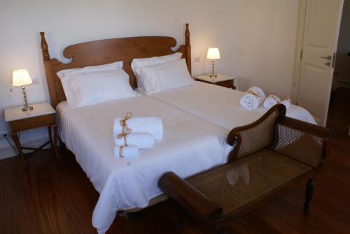 丰沙尔Quinta Paços do Lago的卧室配有一张带白色床单和毛巾的大床。