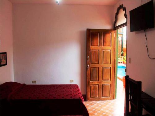格拉纳达马哈拉雅精品酒店的一间卧室配有一张床和一扇木门