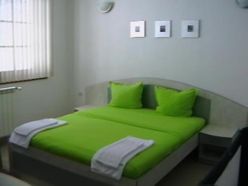 希普科沃Rooms for Guests Bakhus的一张带绿床单和枕头的床