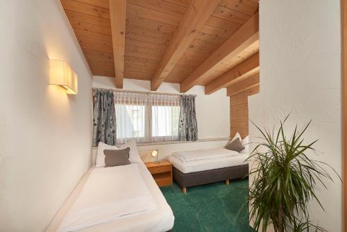 萨尔巴赫Landhaus Zirmhof的客房设有两张床、一张沙发和一个窗口。
