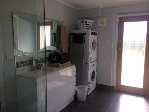汤斯维尔斯特雷顿巷公寓的厨房配有洗衣机、洗衣机和烘干机。