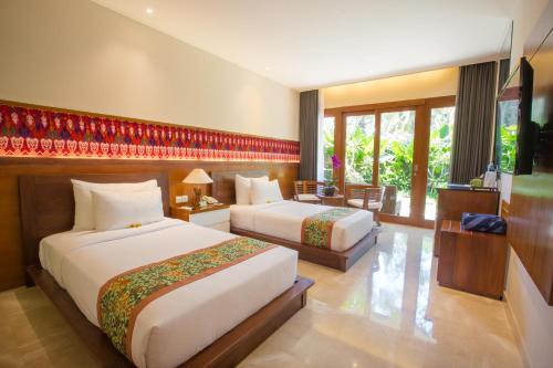 乌布乌布瓦纳度假酒店的酒店客房设有两张床和电视。