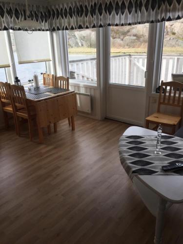 王室港Seaview Cottage Solvik - Kungshamn的一间带桌椅和窗户的用餐室