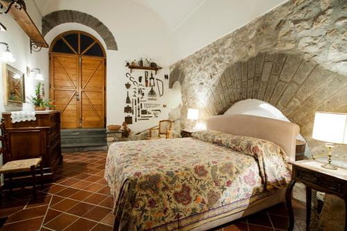 圣安格塔苏德格尔夫Antico Casale Ruoppo的一间卧室设有一张床和石墙