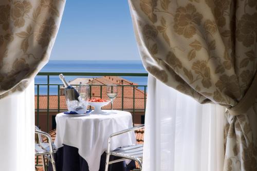 阿拉西奥Hotel Ristorante Toscana的一张桌子和椅子,享有海景