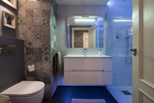 马德里市中心尊贵豪华公寓的一间带卫生间、水槽和镜子的浴室