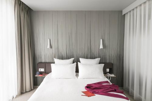 巴黎巴黎凡尔赛门奥科酒店的卧室配有白色大床和白色枕头