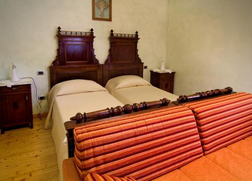 萨维纳迪松佐洛坎达迪维塔克酒店的一间卧室配有两张床、两张桌子和两盏灯。