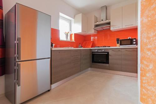普拉Apartment Valmas的带冰箱和橙色墙壁的厨房