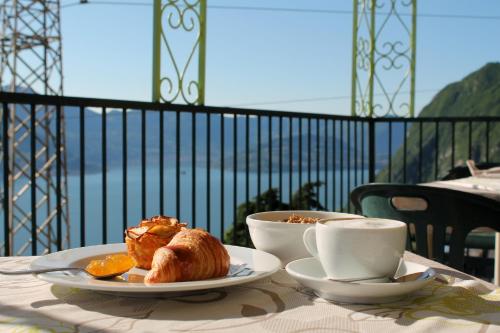 里瓦迪索尔托波焦多乐酒店的阳台上的桌子上放着咖啡和羊角面包