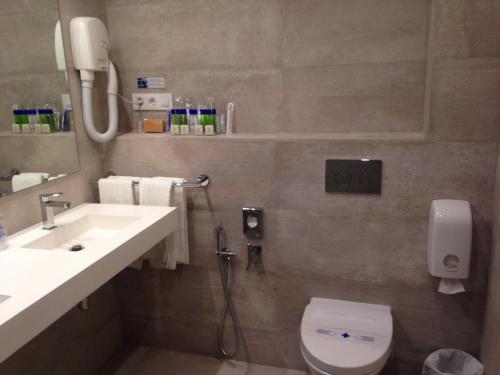 乌迪亚莱斯堡Las Rocas Playa Hotel的一间带水槽、卫生间和镜子的浴室