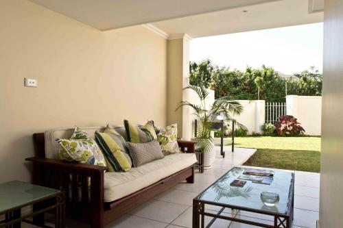 德班D3 Sea Lodge - by Stay in Umhlanga的带沙发和玻璃桌的客厅