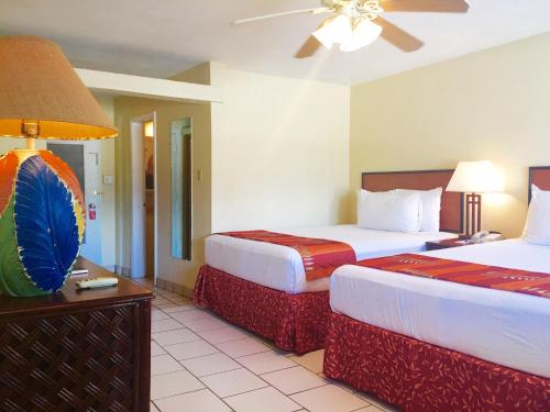 Bolongo博隆戈湾海滩度假酒店的酒店客房配有两张床和吊扇。