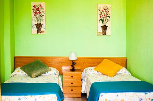 伊斯拉El Encinar de playa de la arena的绿墙客房内的两张床