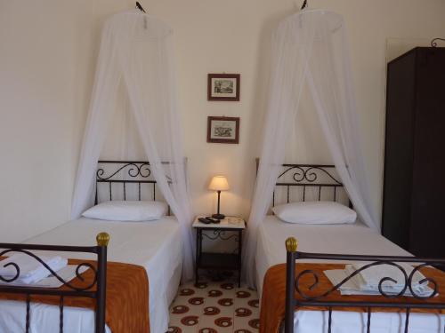 塞里福斯Villa Niki的一间卧室配有两张床和一张带台灯的桌子