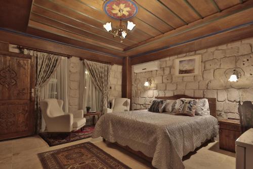 格雷梅谷子德窑洞酒店的一间卧室设有一张床和石墙