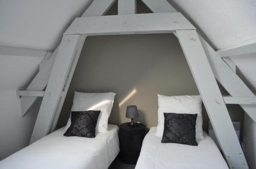 圣马洛Maison Coetquen的白色墙壁客房中的两张单人床