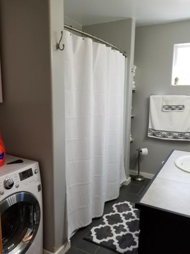 塔尔基特纳古朴典雅度假屋的洗衣房配有洗衣机和白色的浴帘