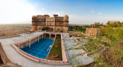 阿尔瓦尔Neemrana's - Tijara Fort Palace的享有带游泳池的建筑的空中景致
