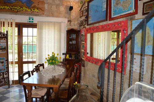 法维尼亚纳Guest House Al Giardino dei Limoni的一间带桌椅的用餐室和一间带窗户的房间