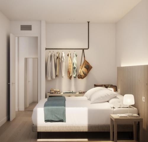 伊维萨镇Sunrise Suites的卧室配有白色的床和衣架