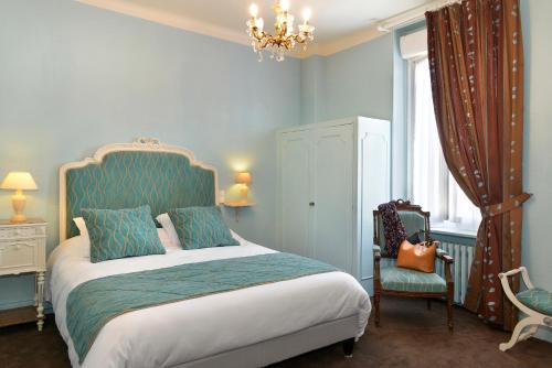 萨勒布里Logis Hôtels Restaurant Le Dauphin的一间卧室配有一张床、一把椅子和一个吊灯。