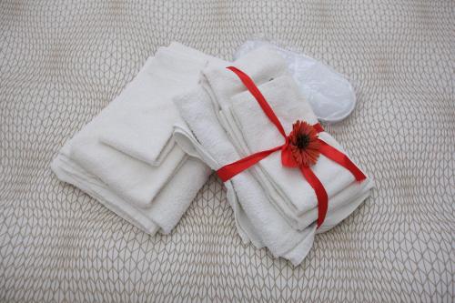 坎帕尼亚诺·迪罗马Just House的床上的白色毛巾和花