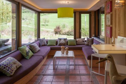 圣玛丽欧米讷Hostellerie Les Bagenelles的客厅配有紫色沙发和窗户