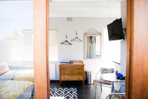 斯泰伦博斯Cobie Apartment的一间卧室配有一张床、一张桌子和一台电视。