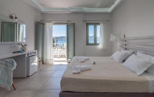 阿达玛斯奥莱亚湾酒店 的白色卧室设有一张大床和一个阳台