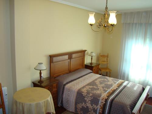 维拉加尔西亚·德·阿劳萨Apartamento Valle Inclán的一间卧室配有一张床、一张桌子和一个吊灯。