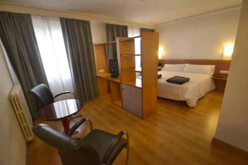 塔拉桑纳阿拉贡布鲁哈斯伊露酒店的配有一张床和一把椅子的酒店客房