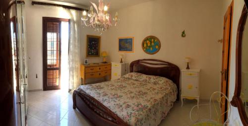 法维尼亚纳Guest House Al Giardino dei Limoni的一间卧室配有一张床、梳妆台和吊灯。