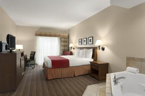 锡达拉皮兹乡村酒店及套房卡尔森 - 锡达拉皮兹机场的酒店客房配有一张床和浴缸。
