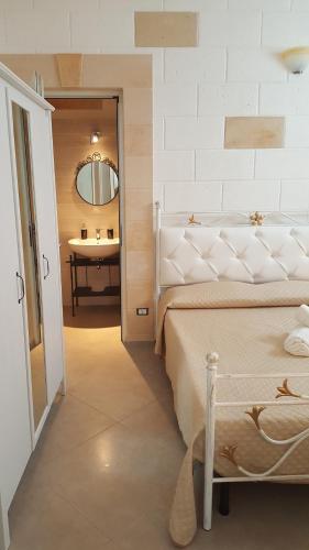 莫诺波利Casa Vacanze Gabriele D'Annunzio的一间卧室配有床、水槽和镜子
