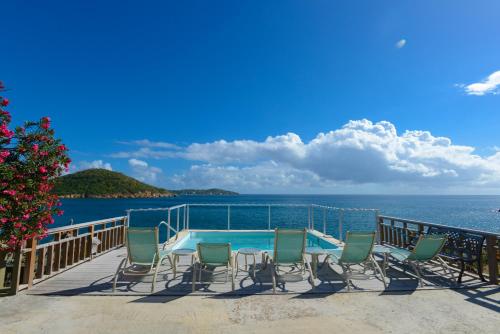 Lindbergh Bay林德伯格湾度假酒店的一个带椅子的甲板和一个游泳池,享有海景