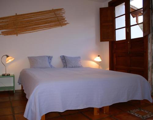 埃尔米瓜Casa Creativa的卧室配有白色床、两盏灯和一扇窗户。
