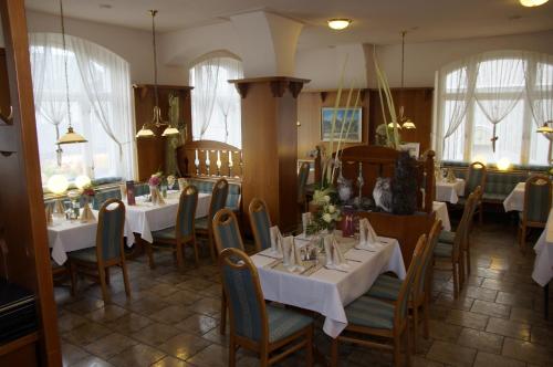 Thum图姆莱茨盖勒旅馆的餐厅设有白色的桌椅和窗户。