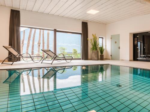 拉纳Garni Hotel Katzenthalerhof的一个带两把椅子的游泳池