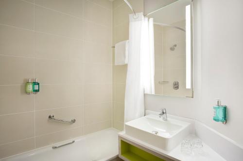 曼彻斯特Leonardo Hotel Manchester Central - Formerly Jurys Inn的白色的浴室设有水槽和浴缸。