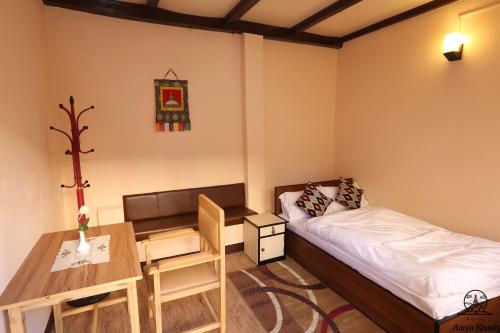 加德满都阿尔亚佛寺酒店的小房间设有一张床和一张书桌