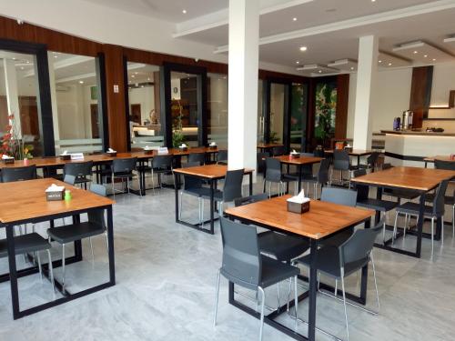 班达亚齐第十七号酒店的餐厅设有木桌、椅子和窗户。