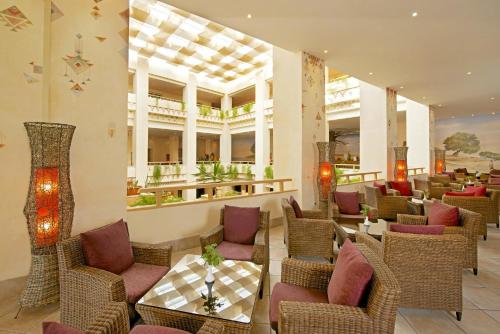 桑戈Vincci Safira Palms的大堂内的餐厅,配有藤椅和桌子