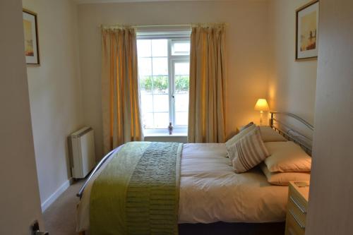 卡兰斯拓克纳尼斯度假屋的卧室在窗户前配有一张床