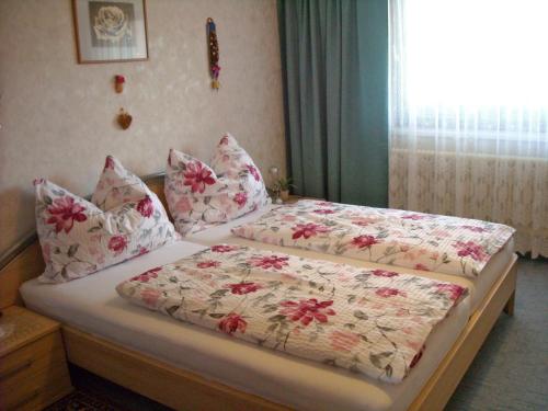 GreisdorfFerienwohnung Zapfl Maria的一间卧室设有两张带花卉图案床单的床和窗户。